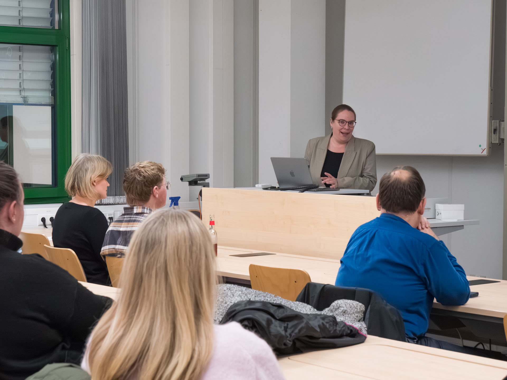 Eine Frau steht an einem Rednerpult vor einem Publikum